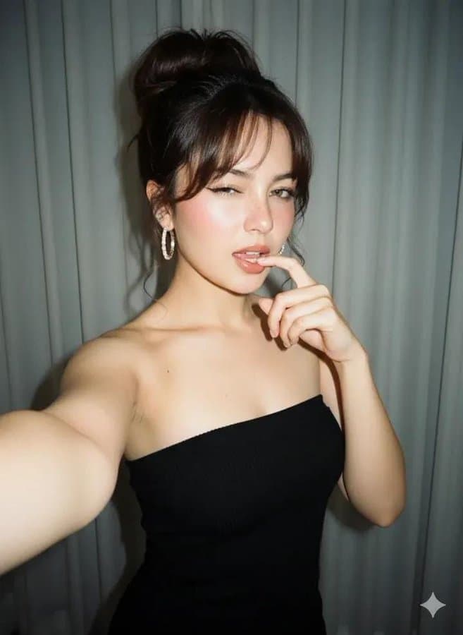 A close-up selfie of a woman standing in a room.